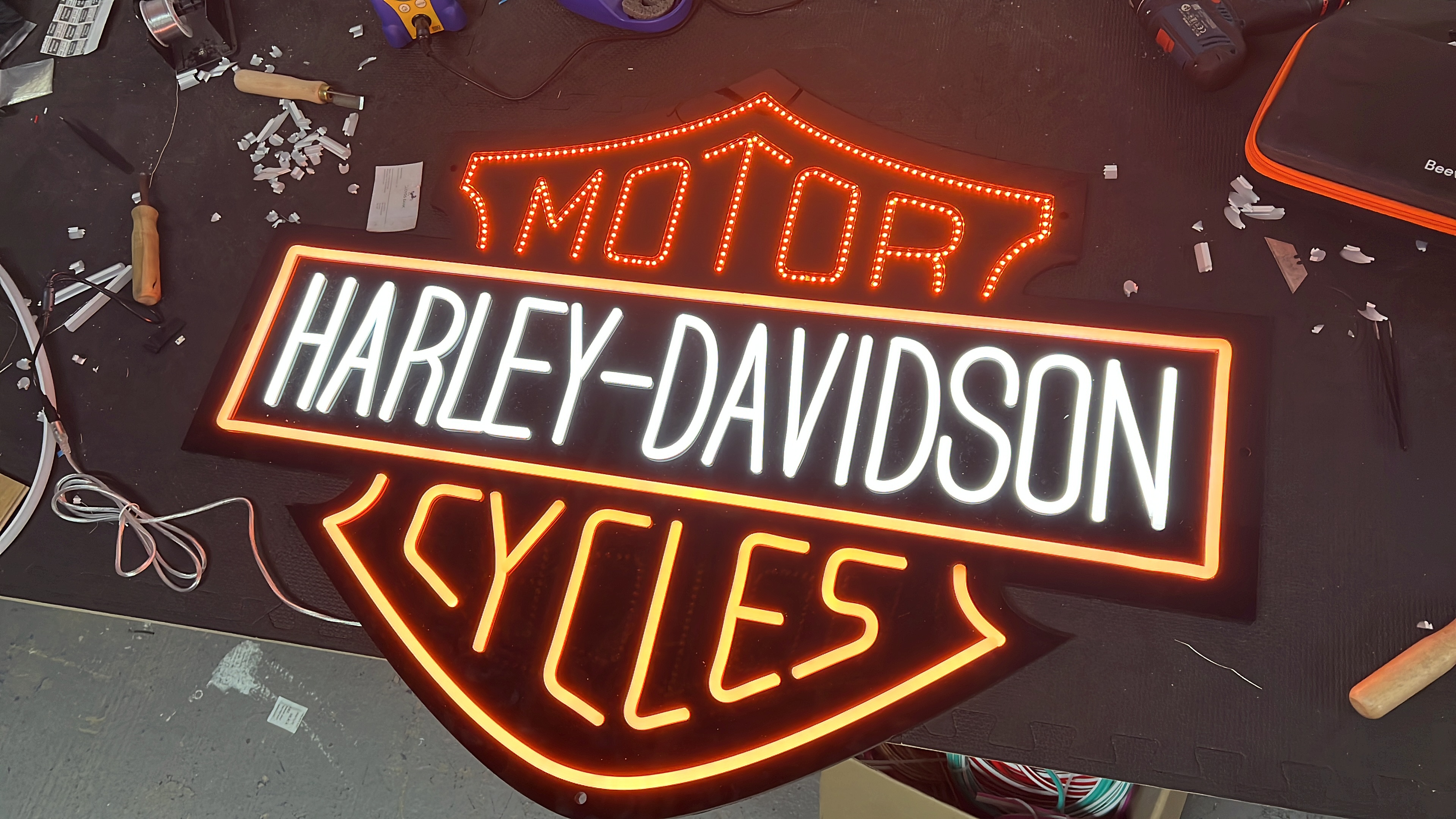 Harley-Davidson illuminated sign on workshop bench