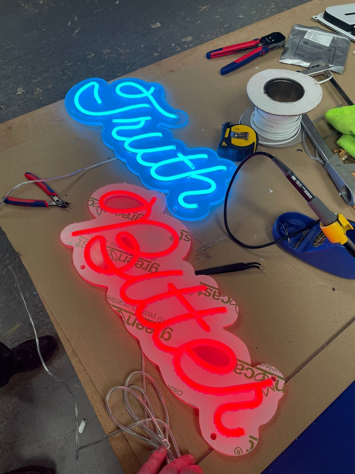 Truth/better neon being assembled on workshop bench