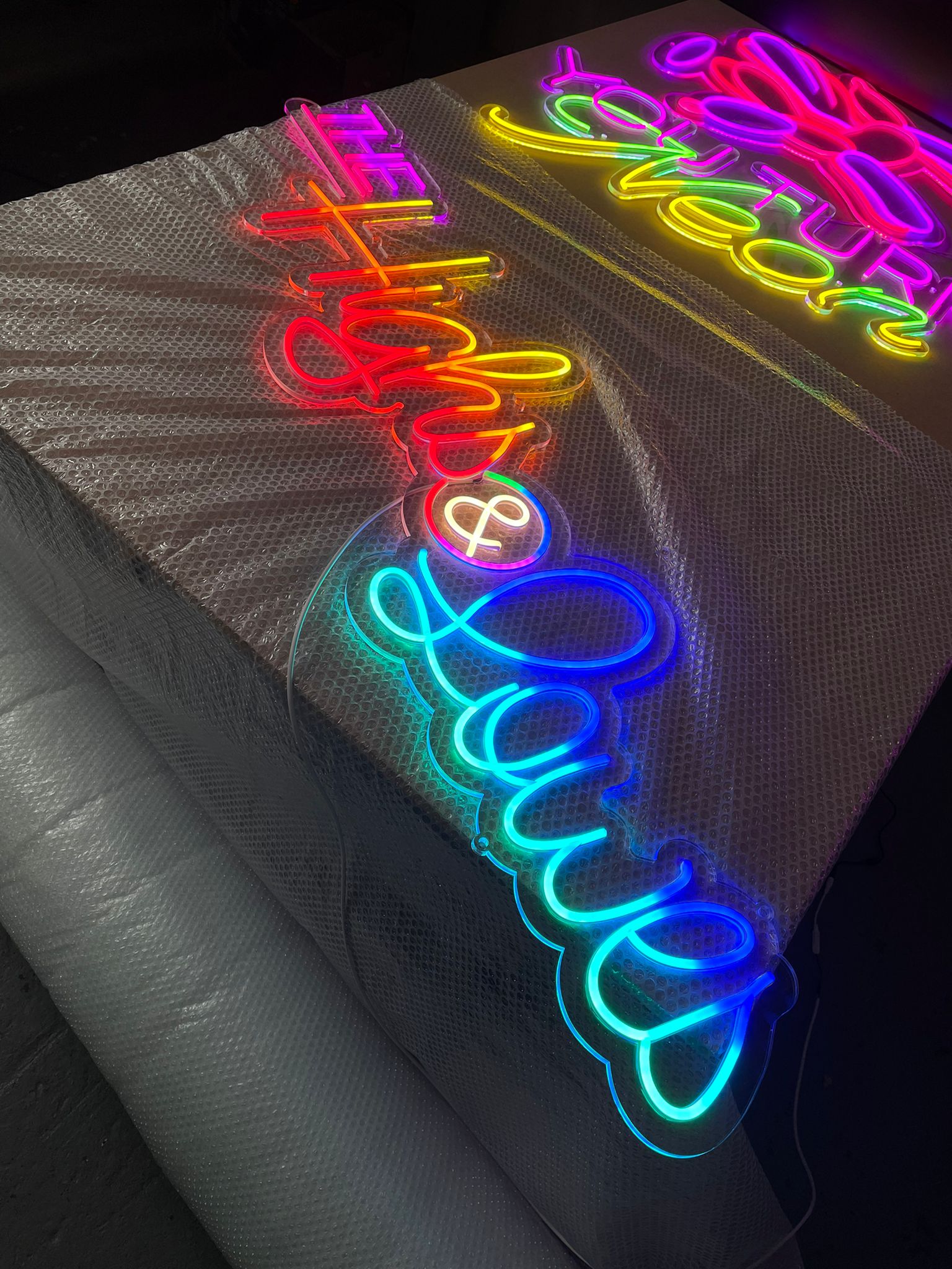 The Highs & Lowes neon on workshop bench