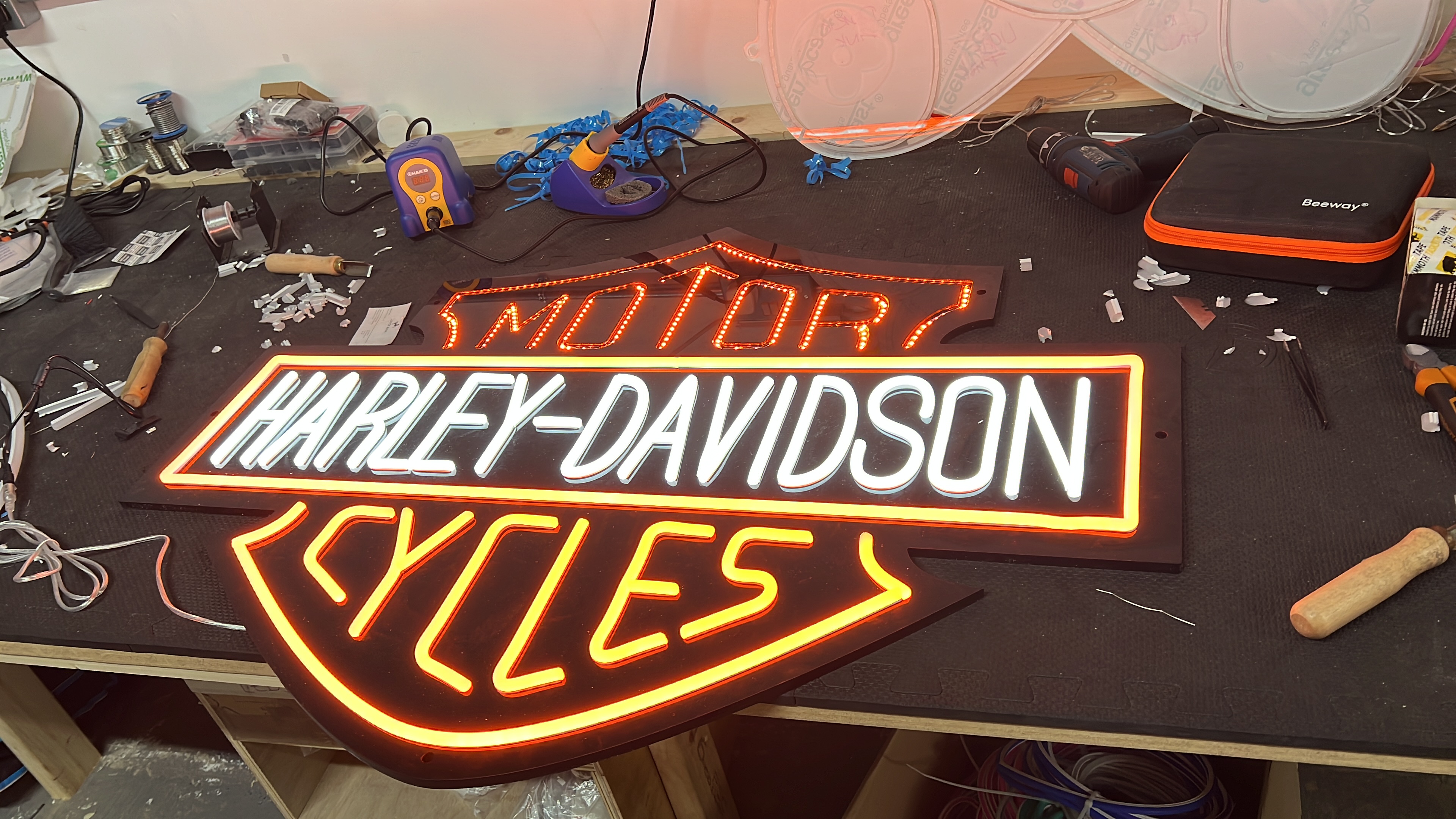 Harley-Davidson sign in fabrication on workshop bench