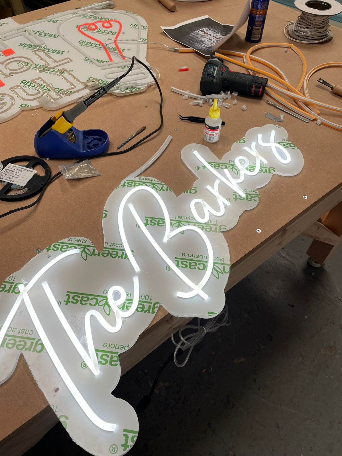 The Barbers neon under construction on workbench