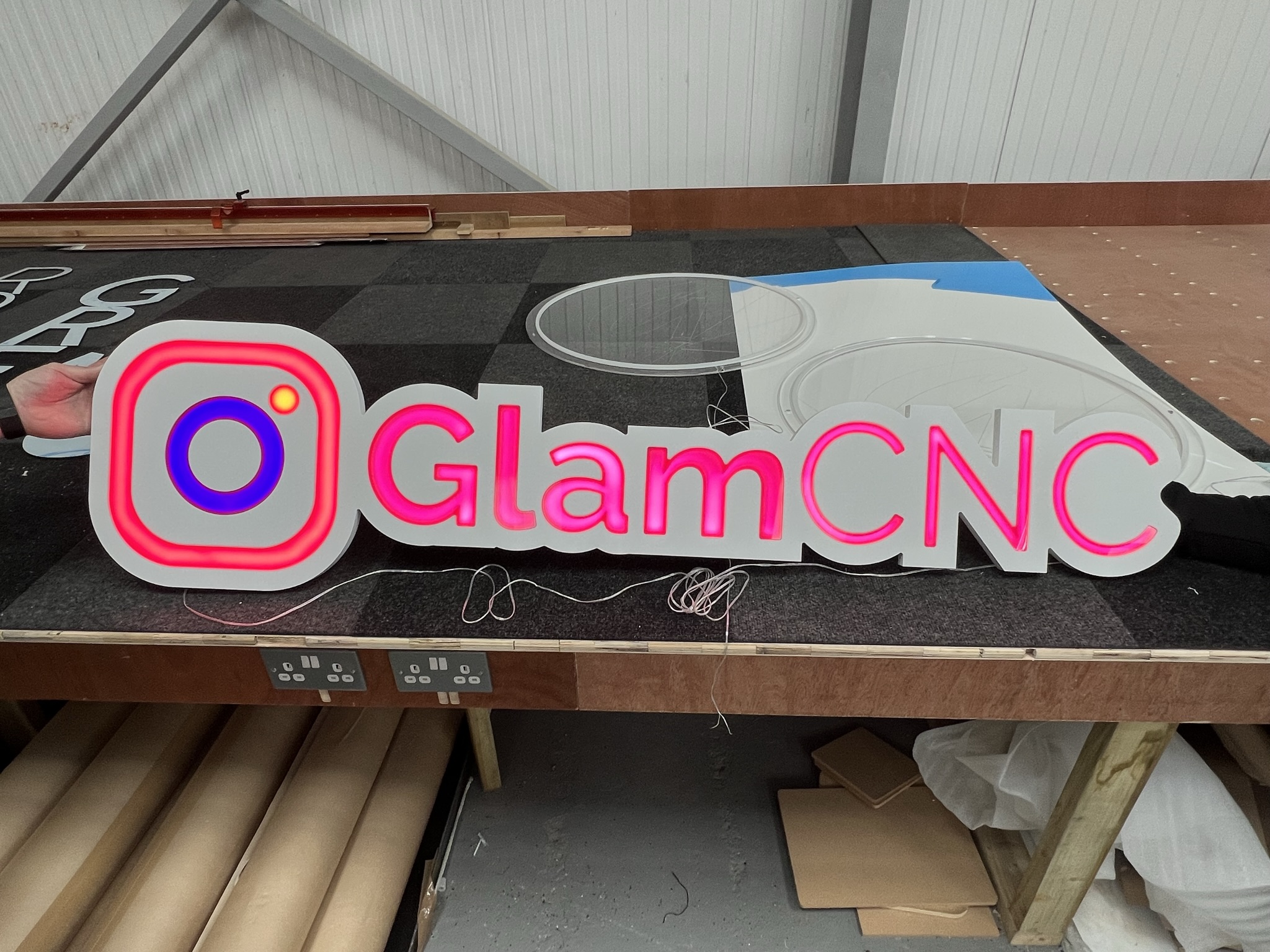 GlamCNC illuminated logo sign on workshop bench