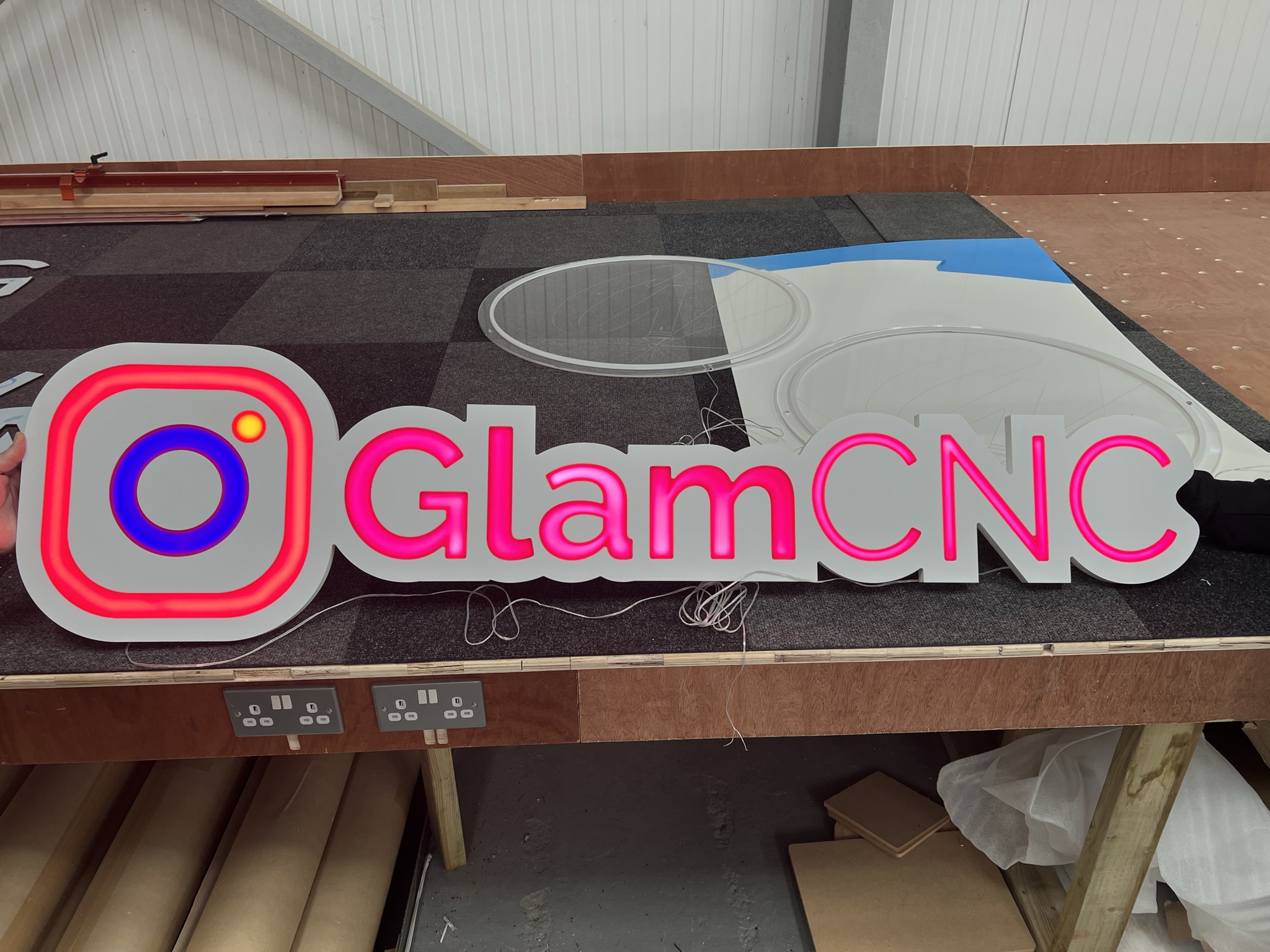 GlamCNC illuminated logo sign on workshop bench