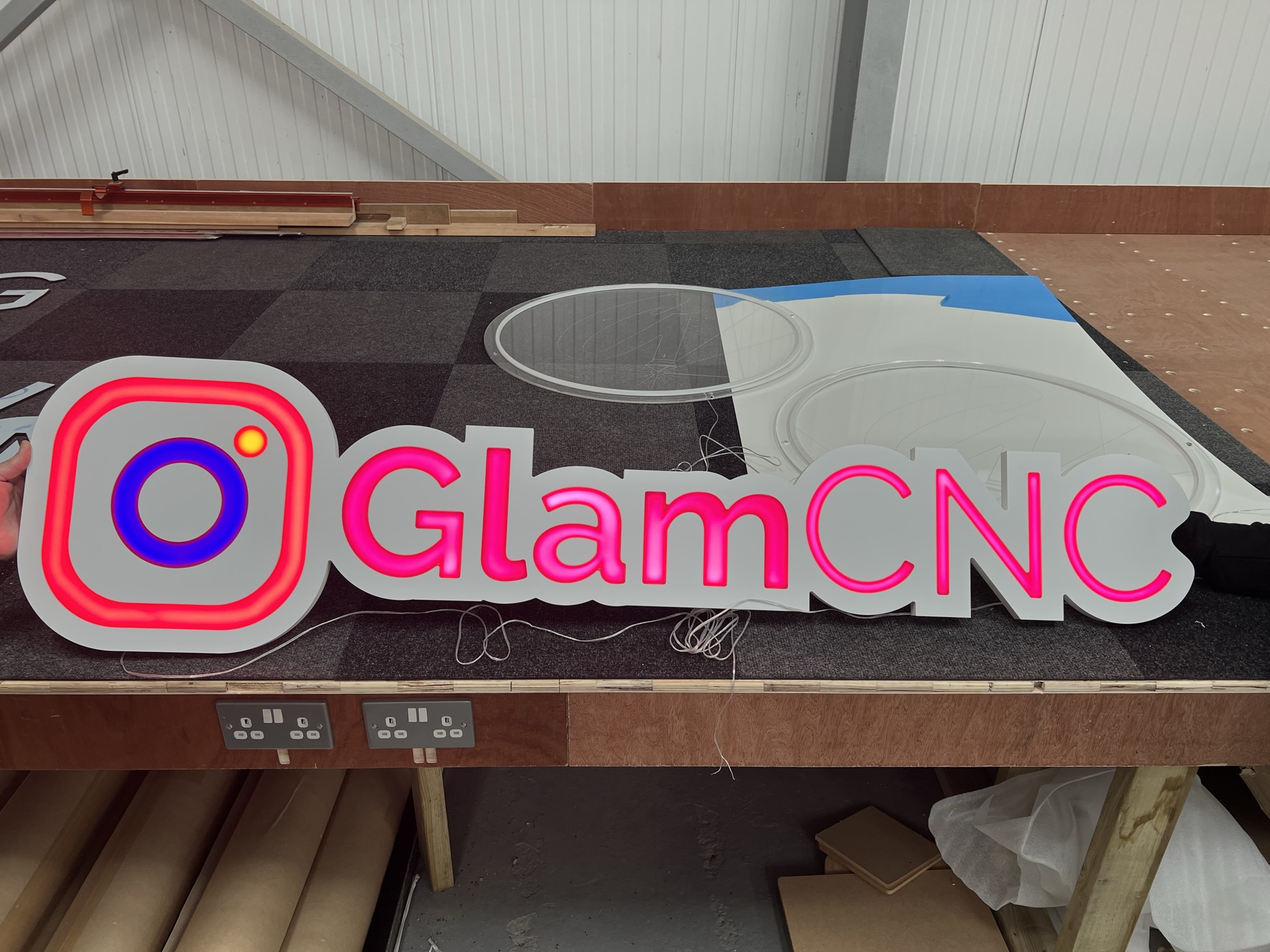 GlamCNC illuminated logo sign on workshop bench