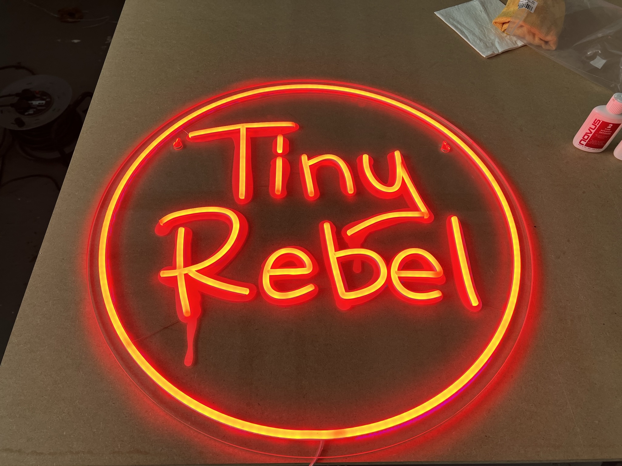 Tiny Rebel red round neon on workshop bench